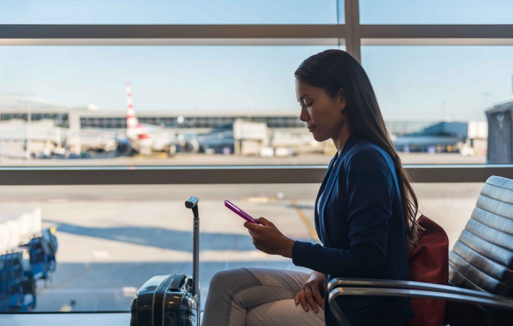 Lady using mobile at the airport - Mobile Plans | MyRepublic